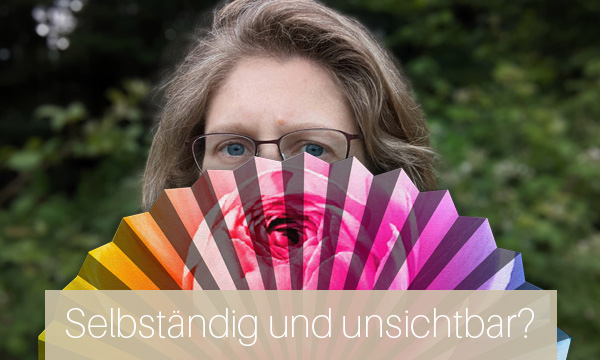 Dorothee versteckt sich hinter einem bunten Fächer