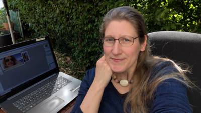 Dorothee auf der Terrasse im Frischluftbüro mit Laptop