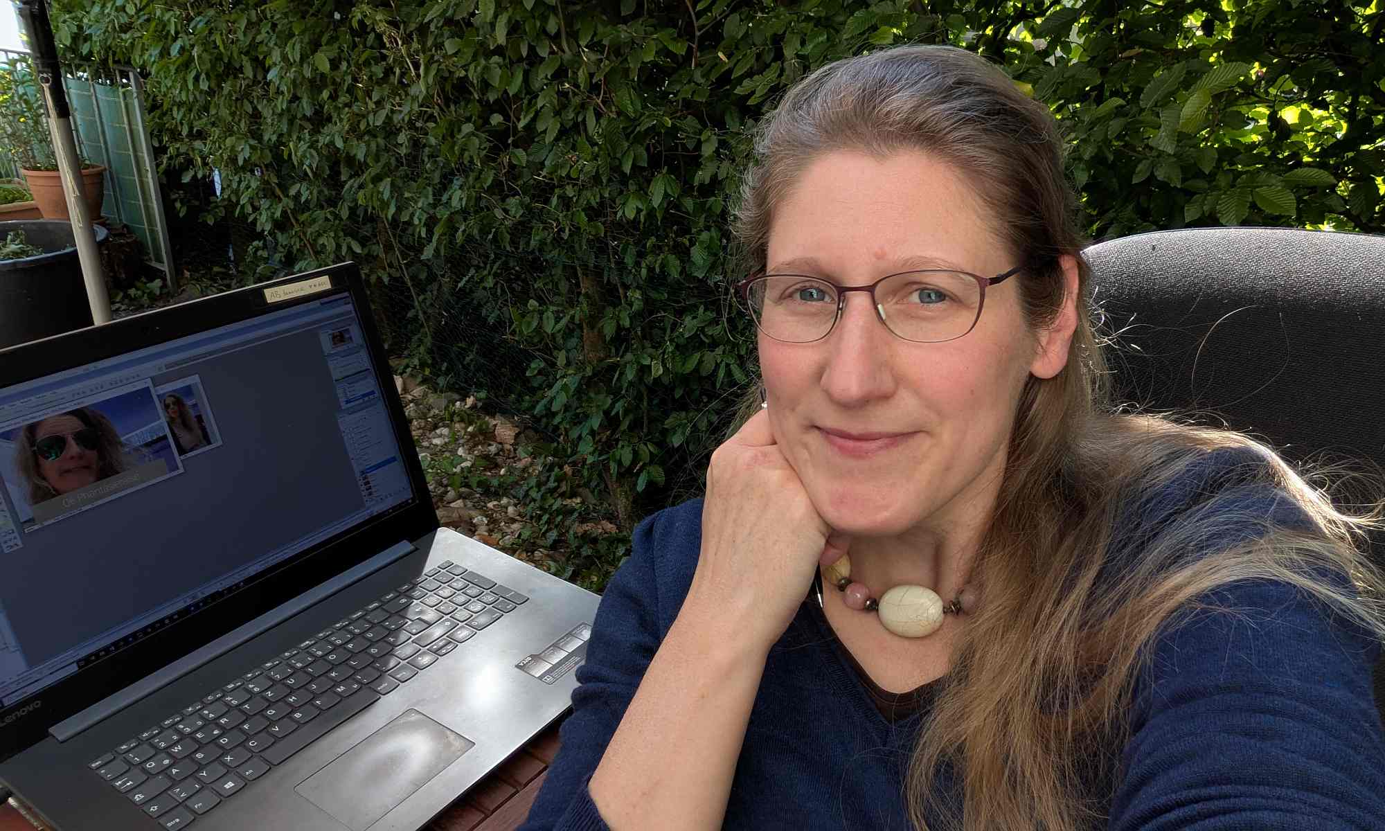 Sichtbar werden mit Dorothee; hier sitzt sie auf der Terrasse mit ihrem Laptop am Tisch und lächelt in die Kamera
