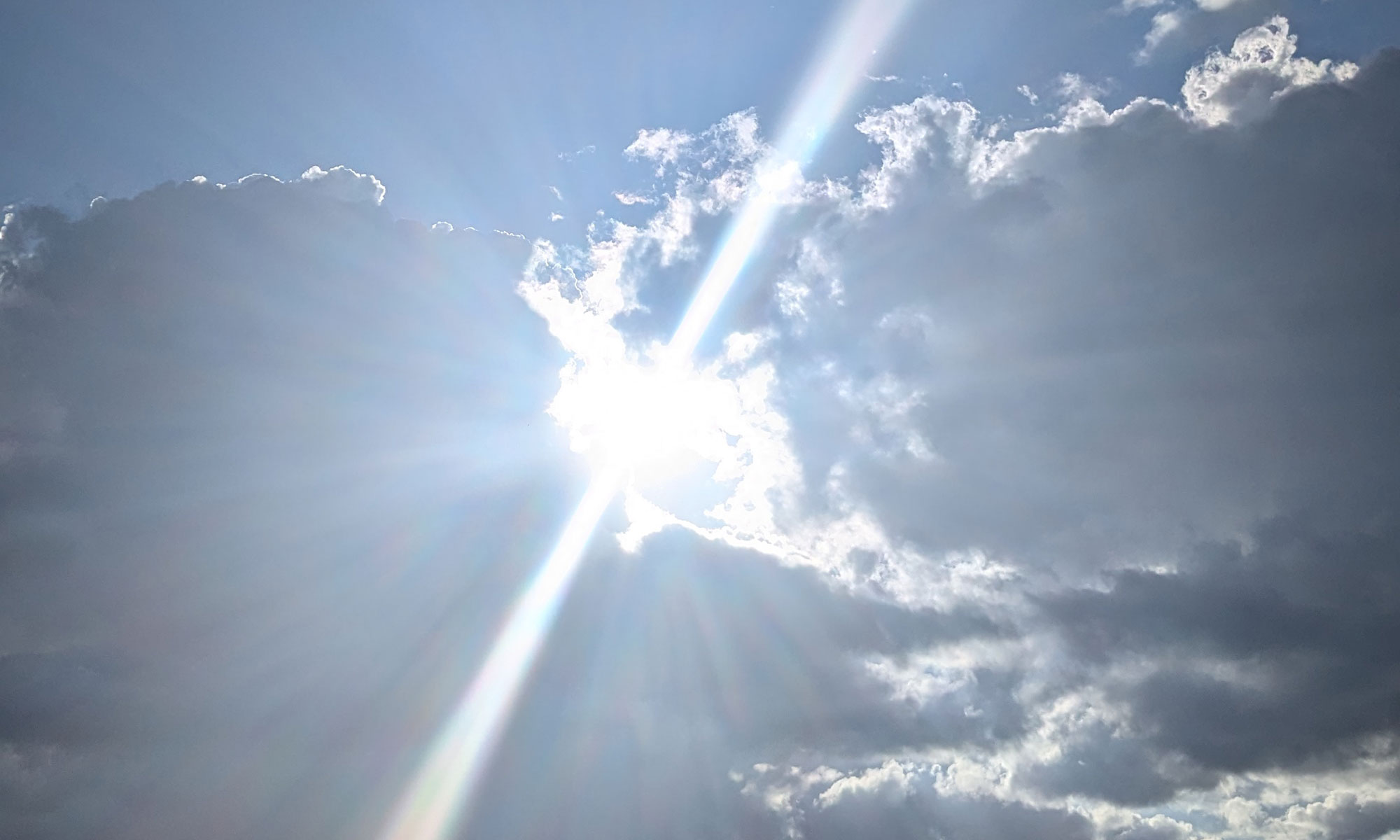 Ein Sonnenstrahl bricht durch Wolken hervor, Fotografie von Dorothee Dickmann