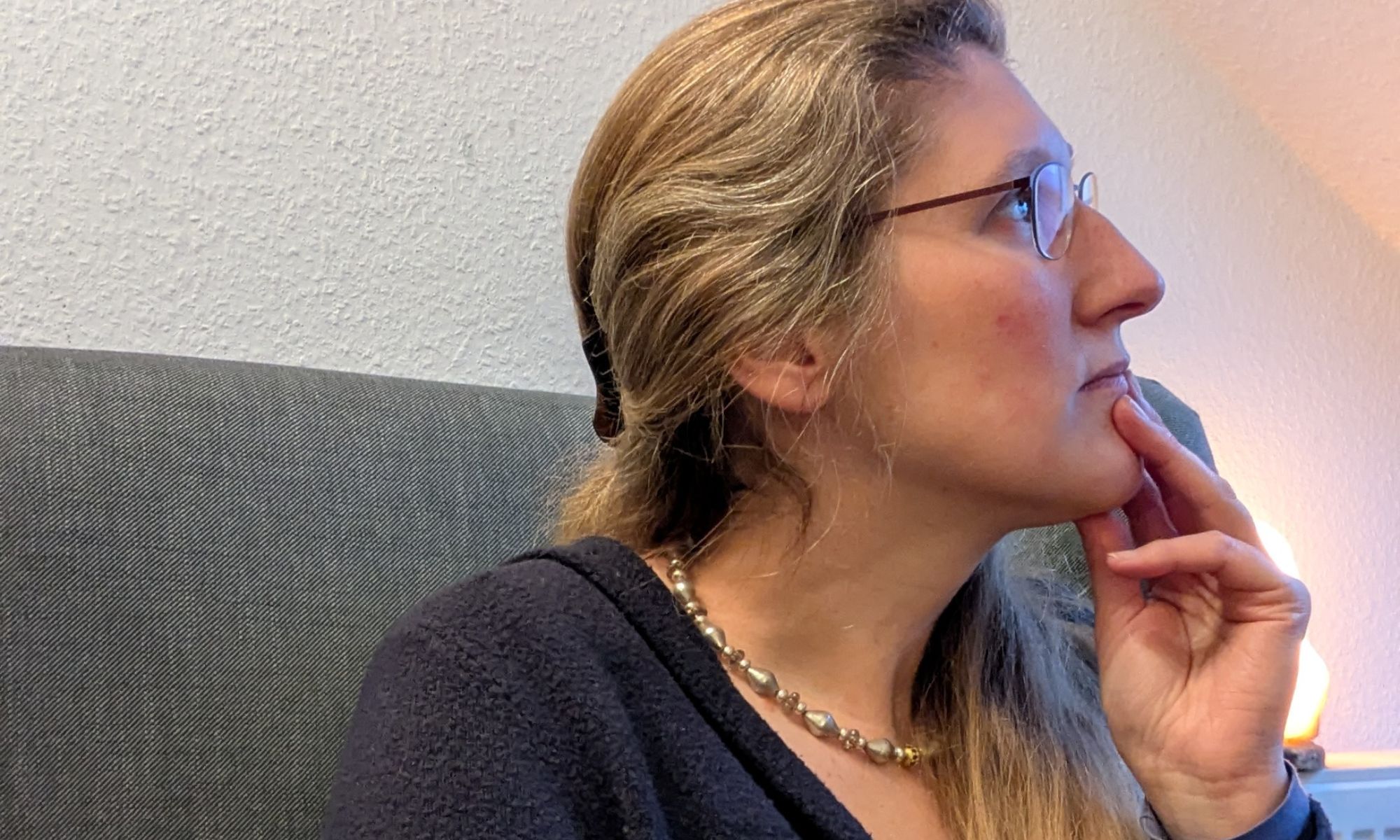 Dorothee sitzt nachdenklich auf einem Sessel. Denn KI ist ein Thema, über das viele Selbständige derzeit nachdenken, ob es ihnen nützt oder nicht und wenn ja, wie.