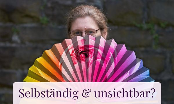 Dorothee versteckt sich hinter einem bunten Fächer